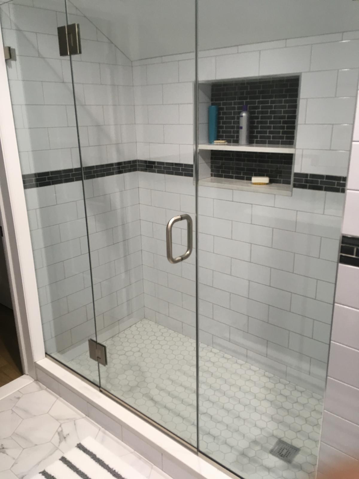 Refurbished bathroom with a newly installed sliding glass shower door.